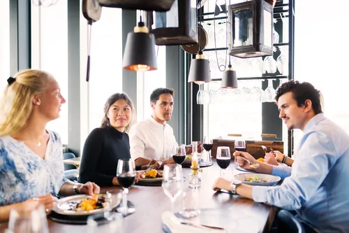 Amigos jóvenes disfrutando de una comida en la mesa