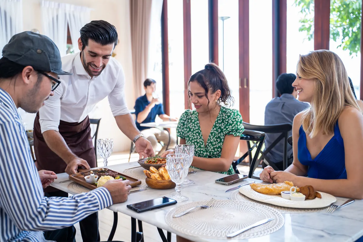 Grupo de amigos charlando mientras comparten la comida