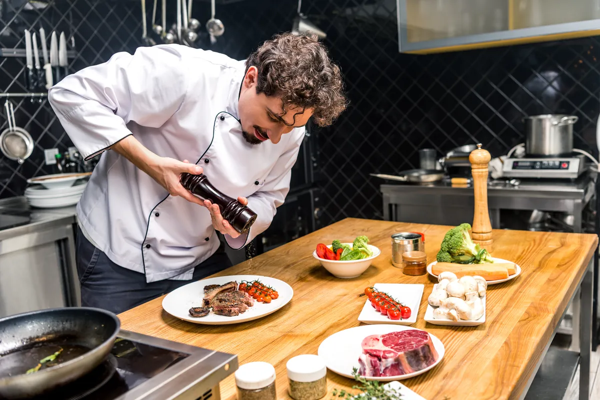 Chef añadiendo pimienta a un plato durante su elaboración