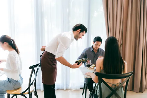 Comensales riendo mientras disfrutan juntos de la comida