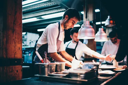 Cocinero emplatando la comida en la cocina del local