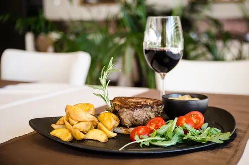 Entrecot con patatas crujientes y una copa de vino tinto