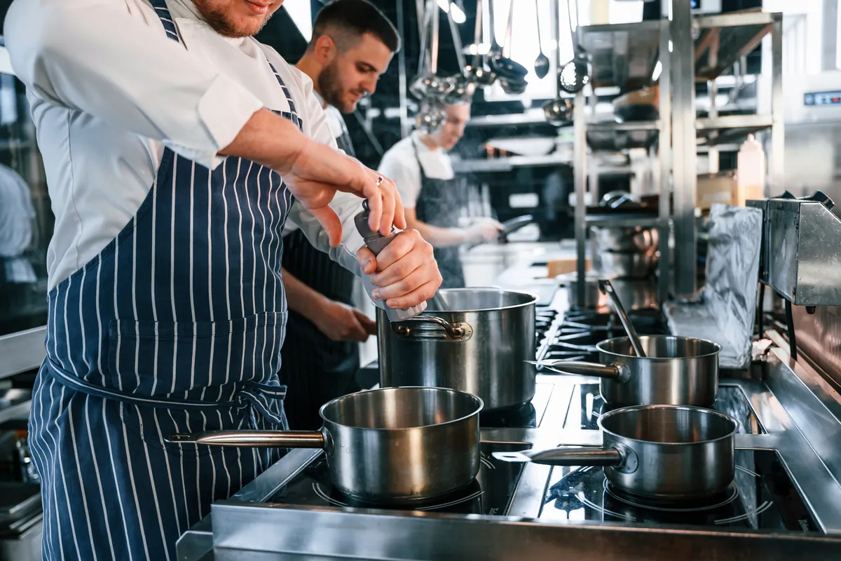 Varios cocineros trabajando a la vez en la cocina profesional