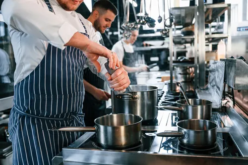 Varios cocineros trabajando a la vez en la cocina profesional
