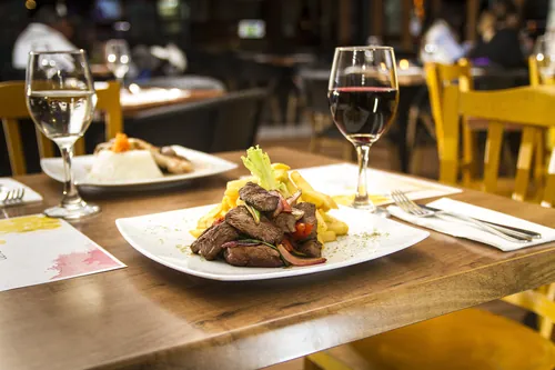 Filete con patatas fritas y vino sobre la mesa