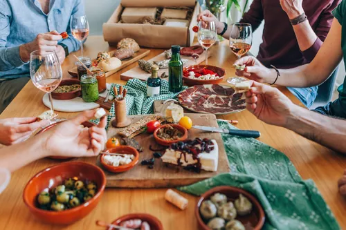 Reunión festiva alrededor de una mesa repleta de aperitivos
