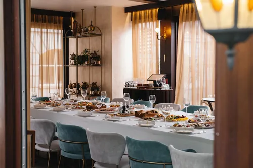 Mesa larga montada con platos y copas para un grupo