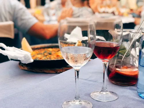 Paella servida en la mesa junto a unas copas elegantes