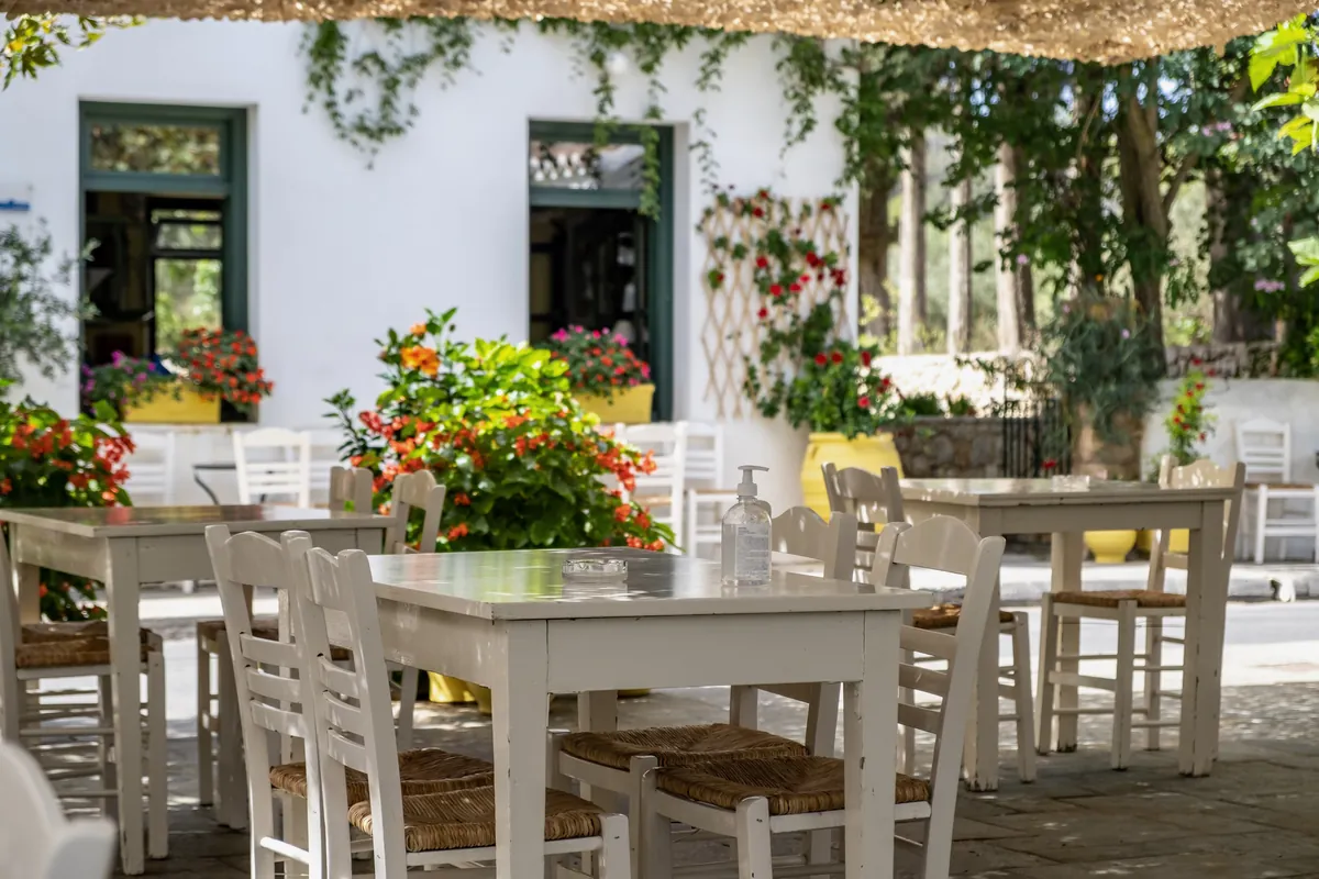 Taberna al aire libre con mesas y sillas mediterráneas