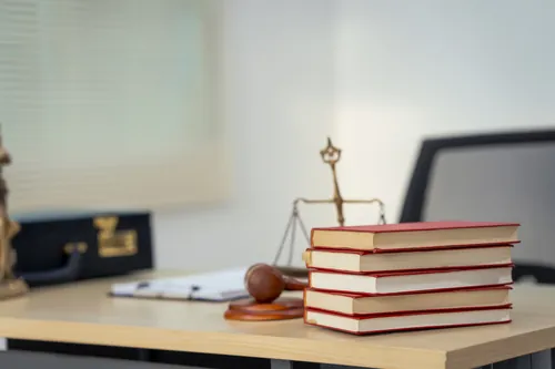 Balanza de la justicia junto a varios libros de derecho