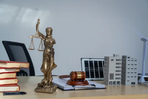 Balanza, mazo y una maqueta de edificio sobre la mesa