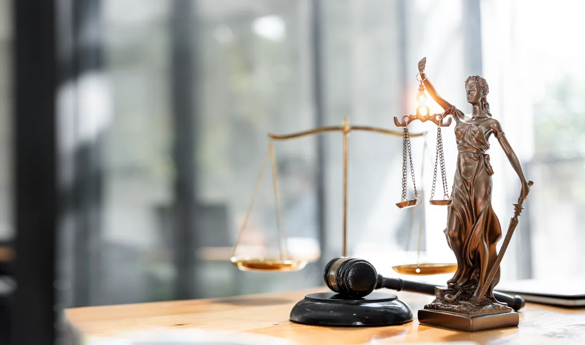Balanza de la justicia y mazo colocados sobre la mesa
