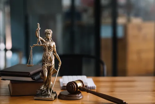Estatua de la justicia y mazo sobre una mesa de madera