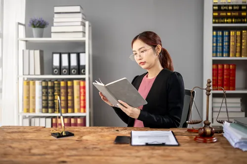 Profesional leyendo un libro en la mesa de trabajo