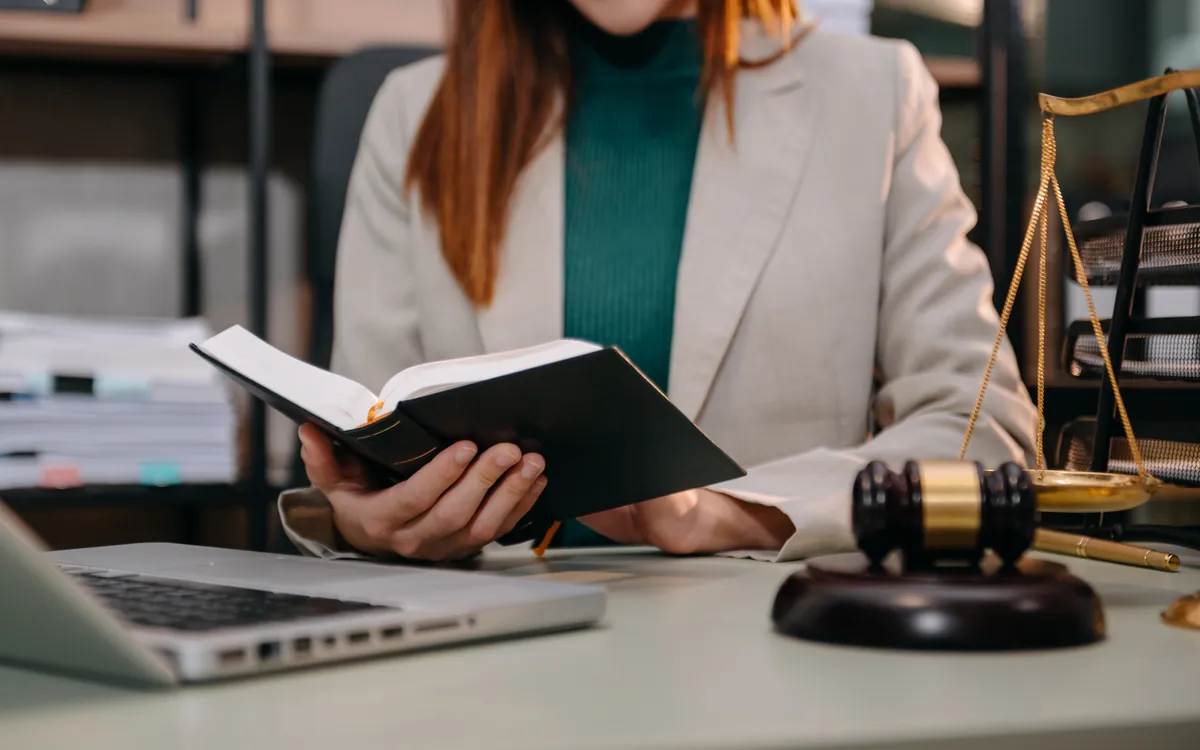 Letrada leyendo jurisprudencia dentro de su propia oficina