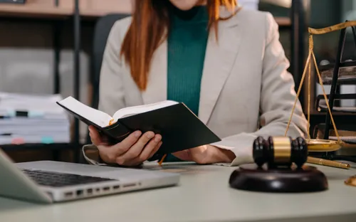 Letrada leyendo jurisprudencia dentro de su propia oficina