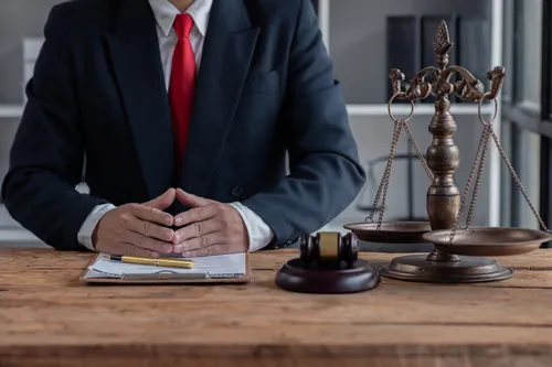 Letrado sentado a la mesa junto a la balanza de la justicia