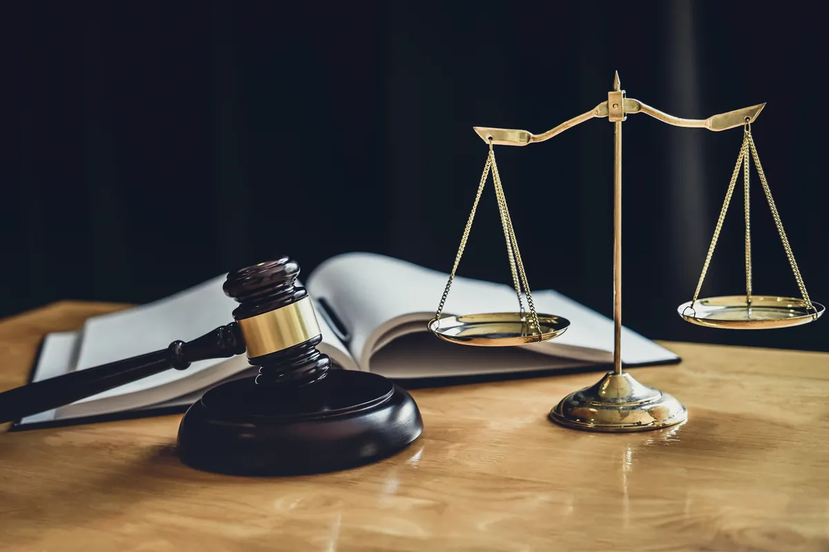 Mazo y balanza acompañados de un libro de derecho