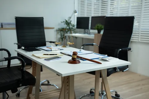 Oficina con el mazo y varios expedientes sobre la mesa