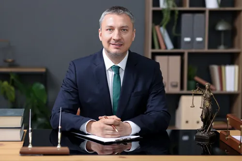 Profesional con traje azul marino sentado a su mesa