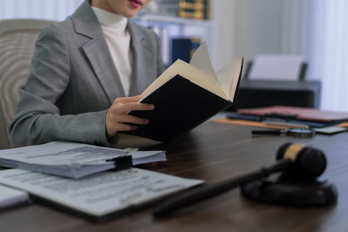 Profesional con traje gris revisando unos documentos del expediente