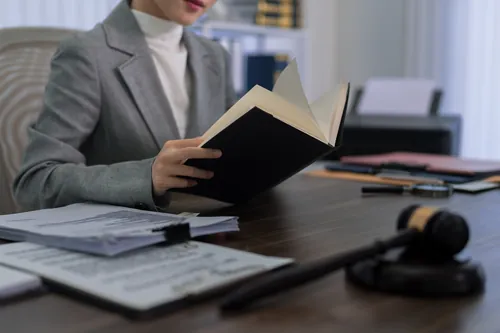 Profesional con traje gris revisando unos documentos del expediente