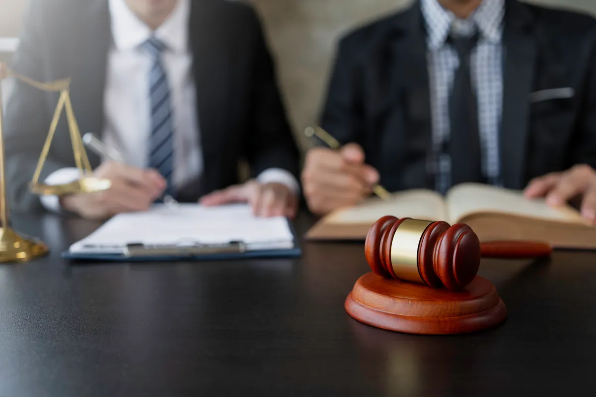 Profesionales trabajando con el mazo y documentos sobre la mesa