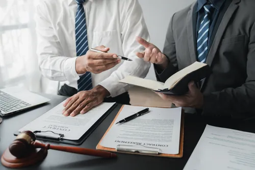 Dos profesionales revisando las cláusulas de un contrato