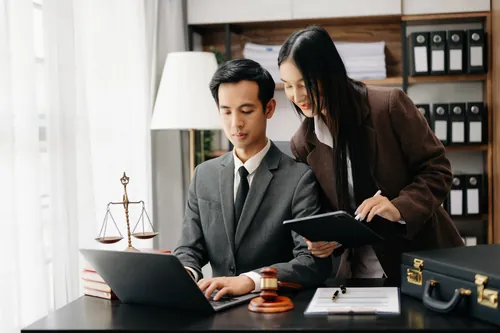 Profesionales revisando documentación en la pantalla de un portátil
