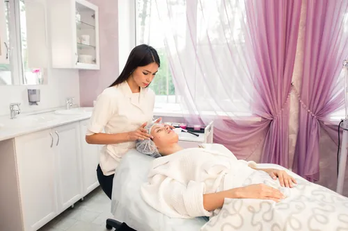 Clienta recibiendo un tratamiento facial tumbada en la cabina