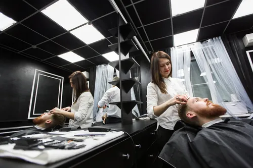Profesional perfilando las cejas a un cliente en el centro de estética